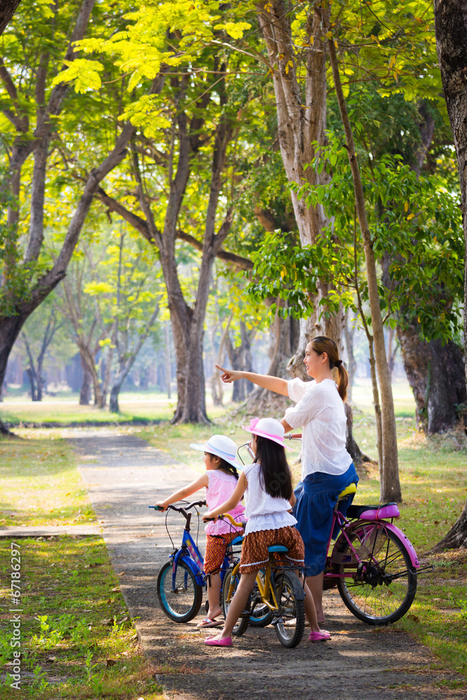 Asian child with mother on bike, active family concept