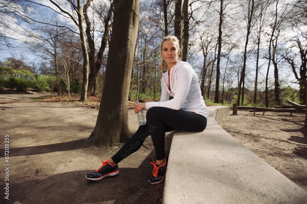 Female runner taking a rest from training in nature