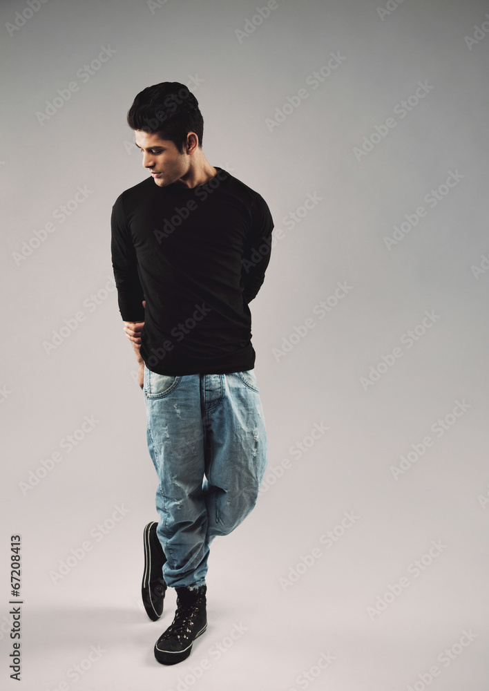 Hispanic young man in casuals posing on grey background