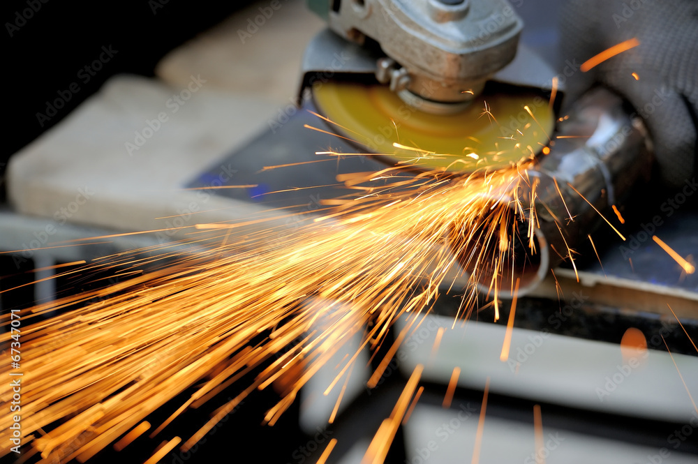 Worker cutting metal with grinder