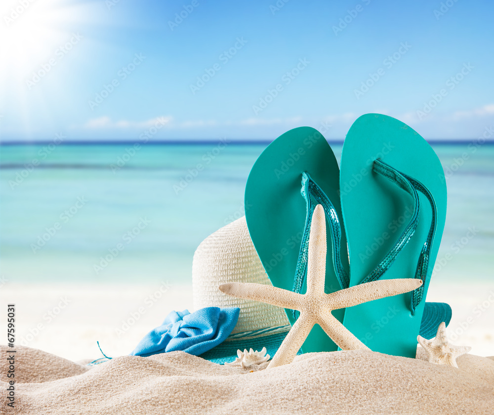 Summer beach with blue sandals and shells