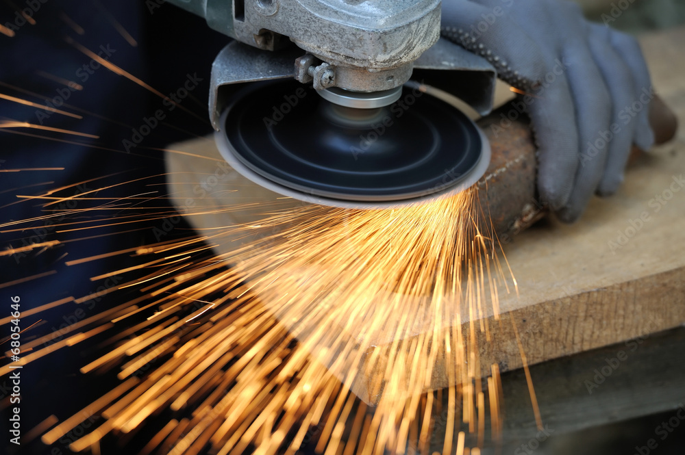 Worker cutting metal with grinder