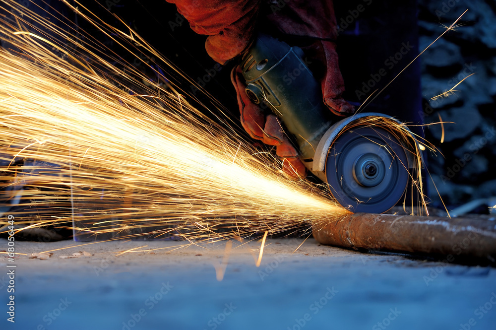 Worker cutting metal with grinder