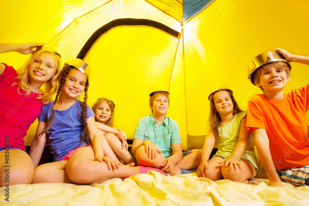 Six children having fun in a tent