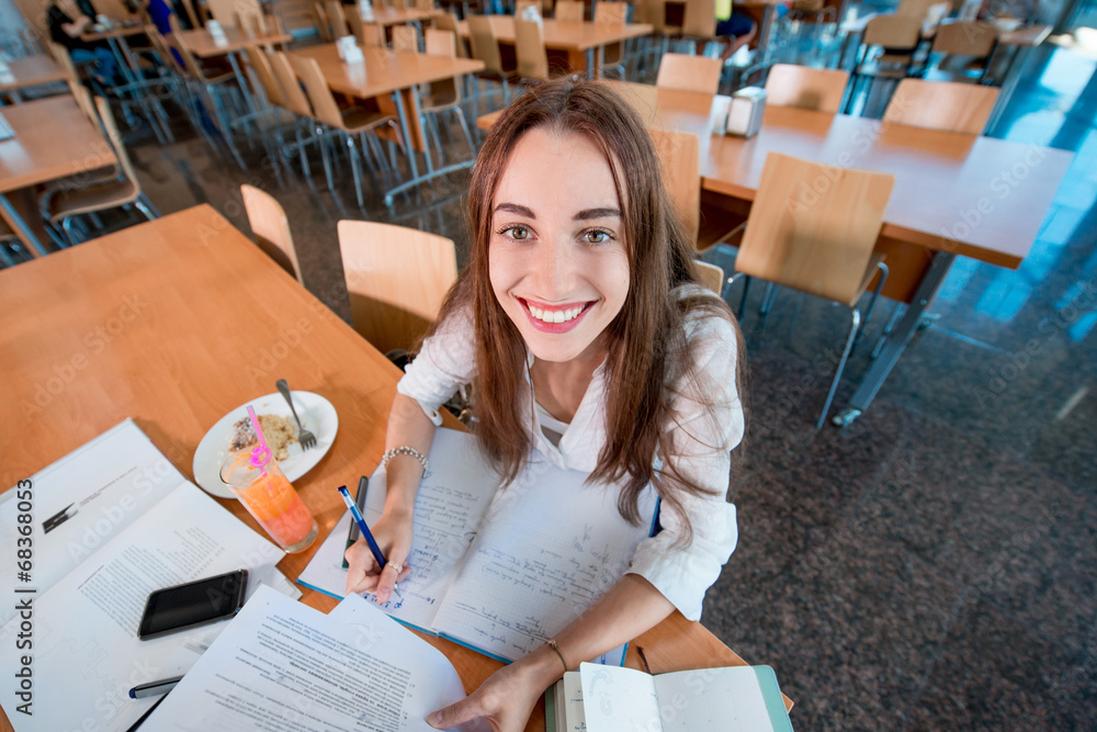 在大学食堂学习的女孩带着新鲜和蛋糕