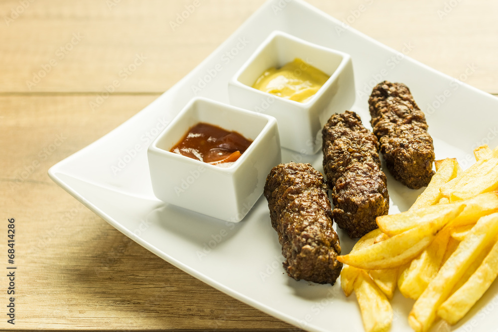 Traditional Romanian Mici And Fries With Ketchup And Mustard