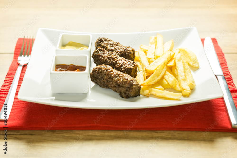 Traditional Romanian Mici And Fries With Ketchup And Mustard