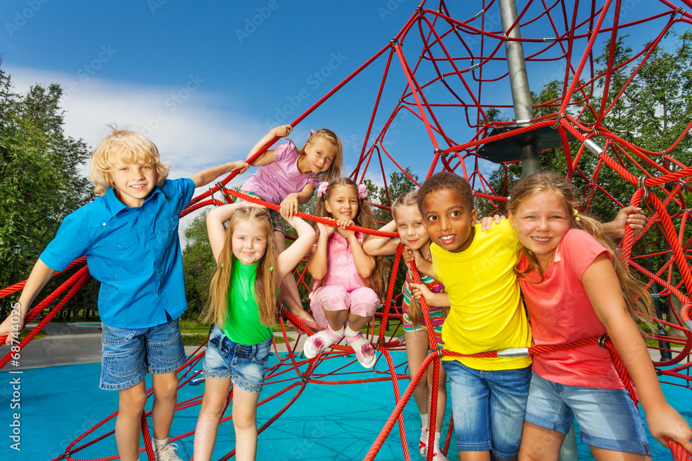 Group of children stand on red ropes and play