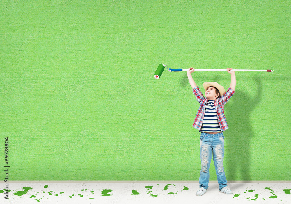 boy in a hat with a roller for painting