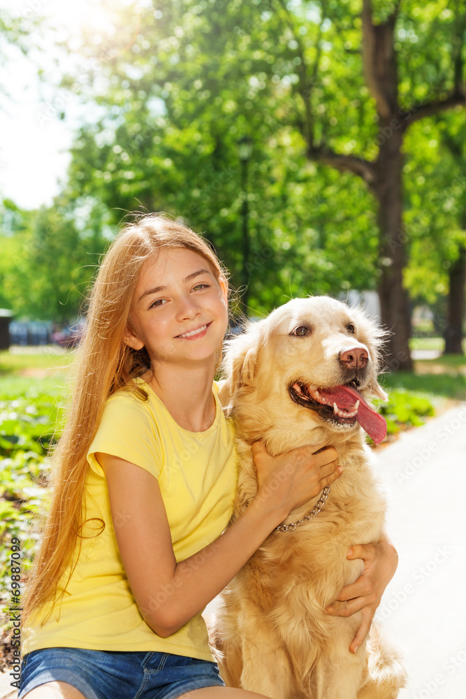 青少年金发女孩与寻回犬在一起