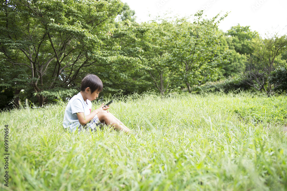 男孩在公园里操作手机