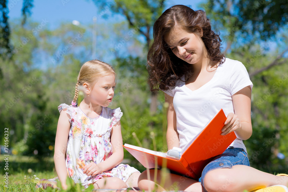 girl and a young woman reading a book together