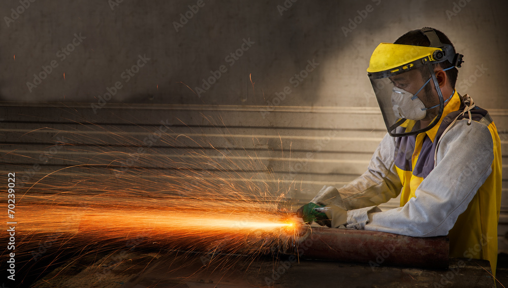 Electric wheel grinding on steel structure in factory