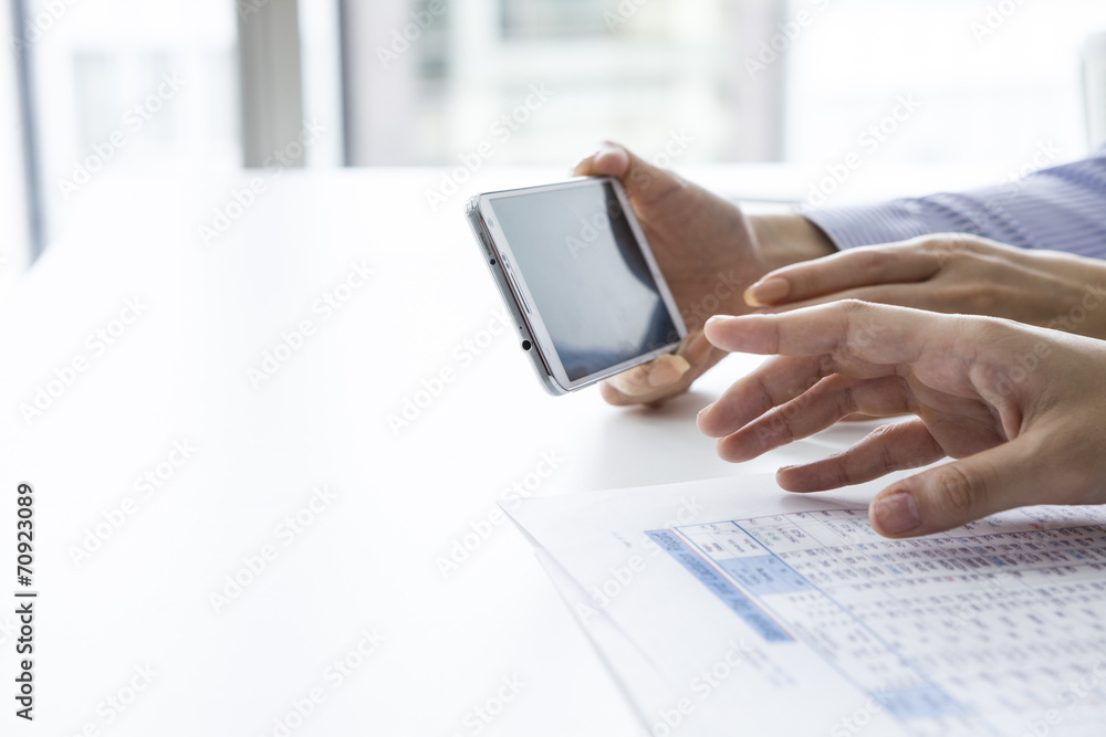 The hands of women to check the mobile phone in the office