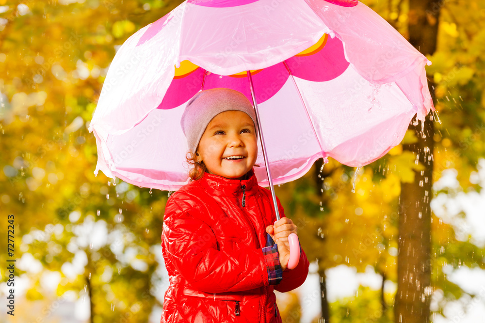 Positive girl with umbrella standing under rain