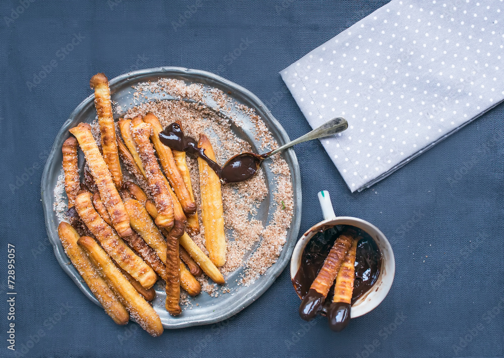 在亚麻布背面的金属板上放巧克力酱的Churros