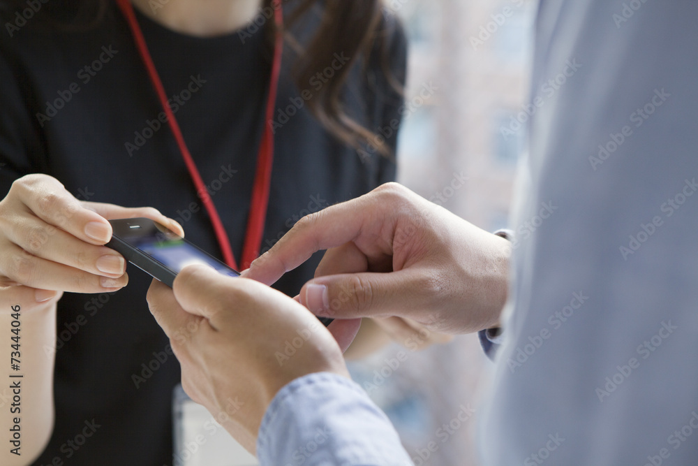 女人看着一个拿着手机的男人