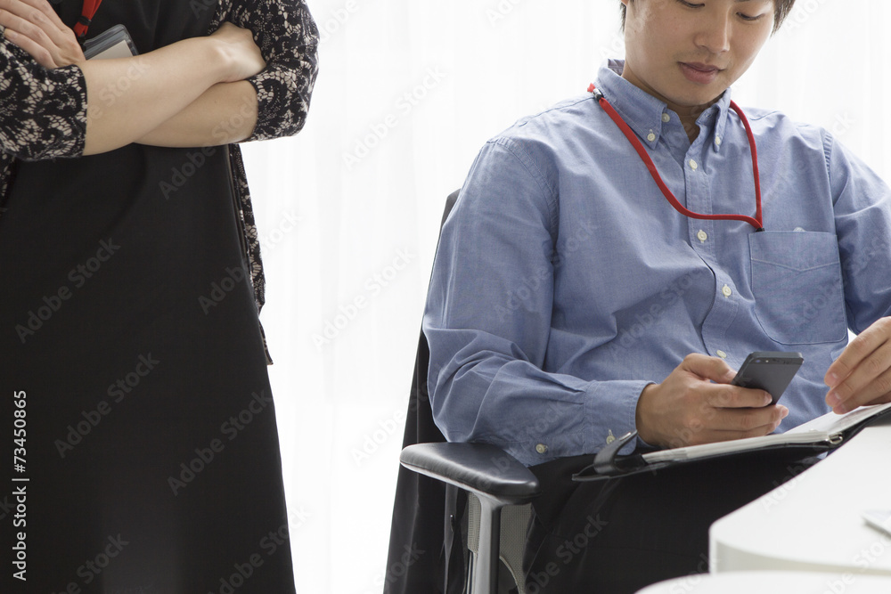 Man sitting and women who are arm in arm