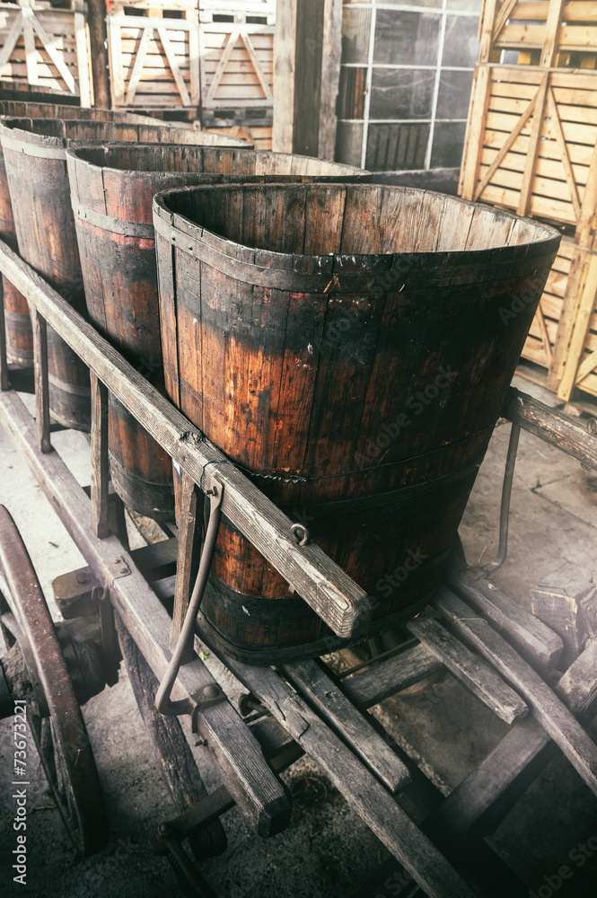 Old wooden wheelbarrow with vats