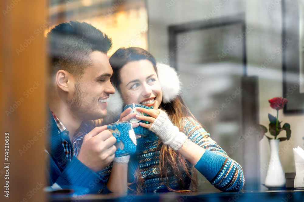 Young couple with coffee at the cafe in winter