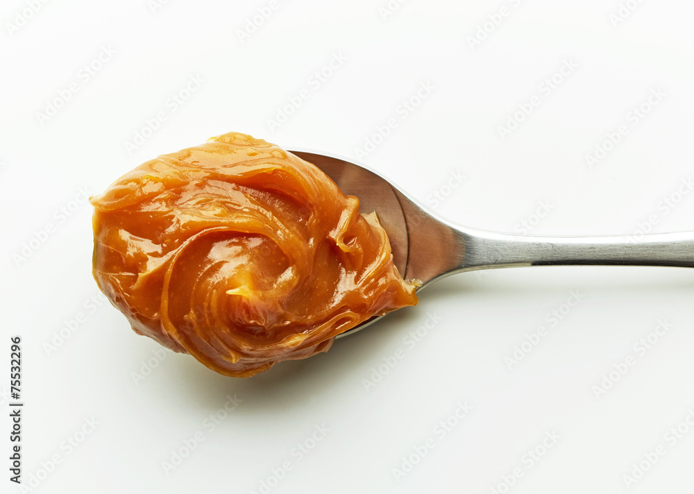 Spoon of melted caramel cream