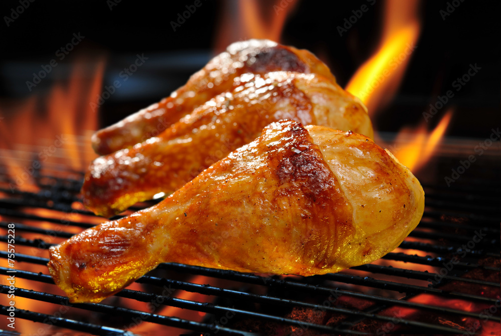 Grilled chicken legs on the flaming grill