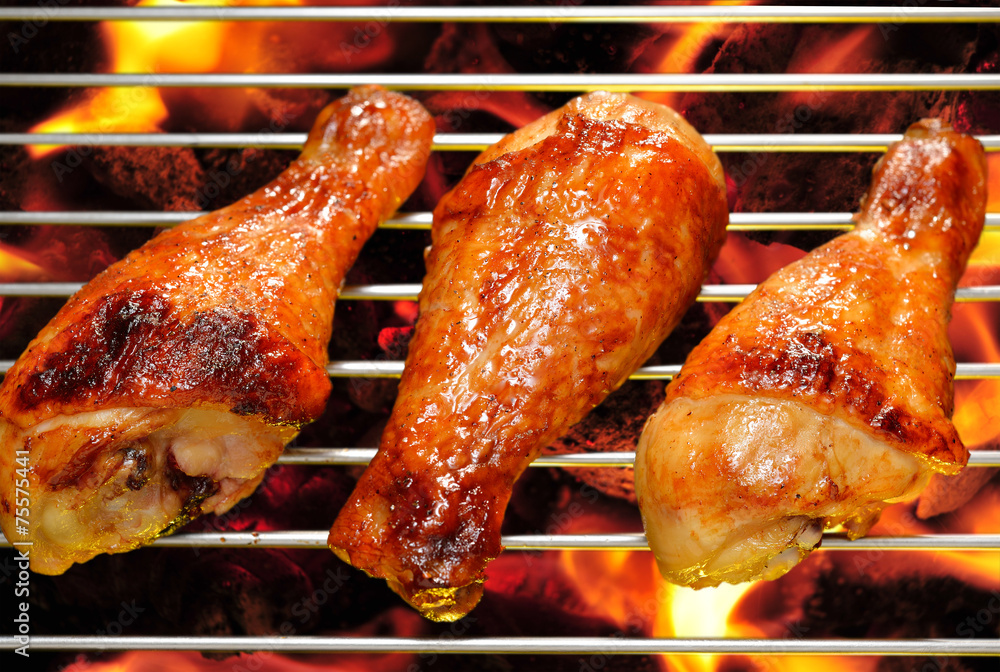 Grilled chicken legs on the flaming grill