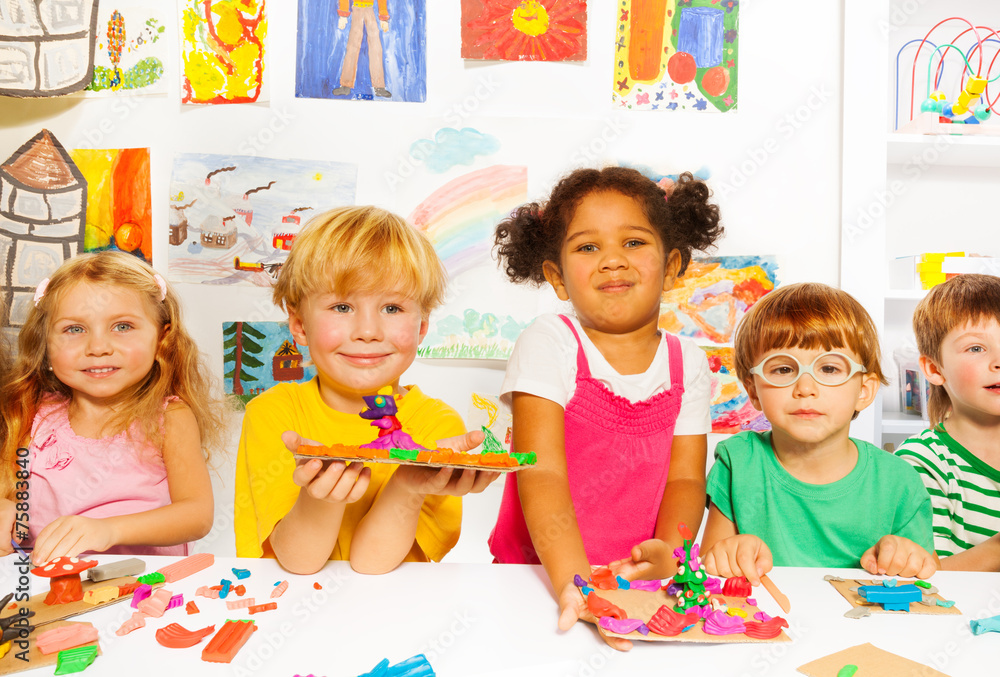 Happy kids with modeling clay in classroom