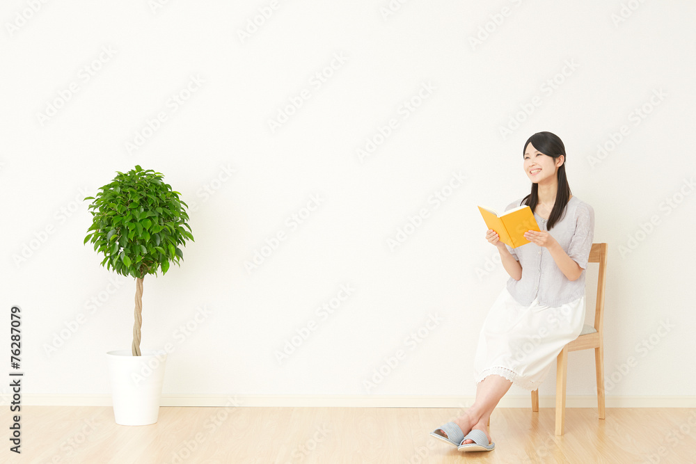 部屋で本を読む女性