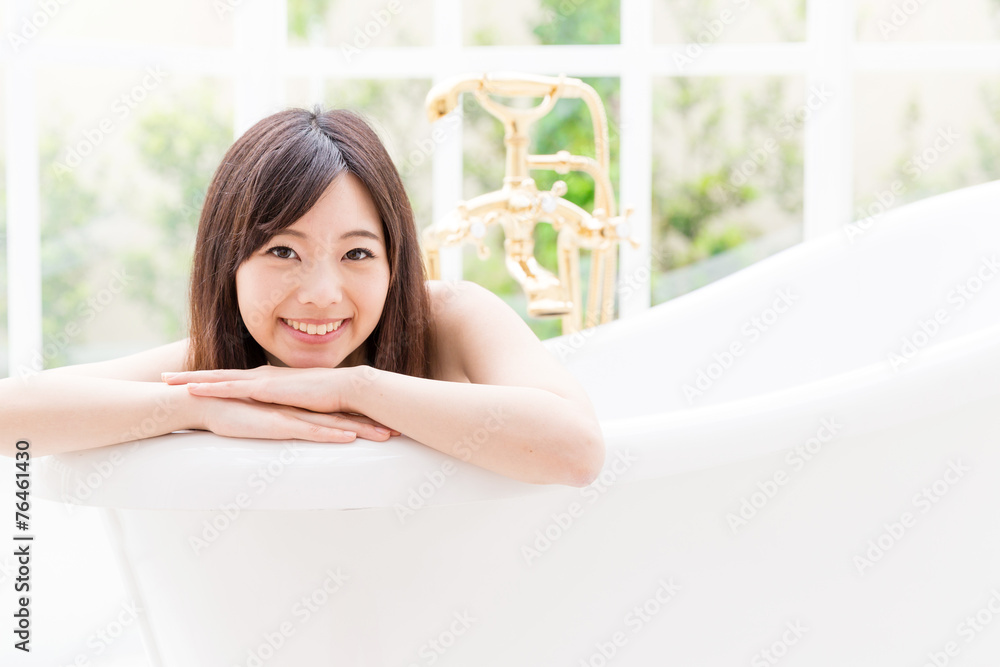 young asian woman relaxing in the bathtub