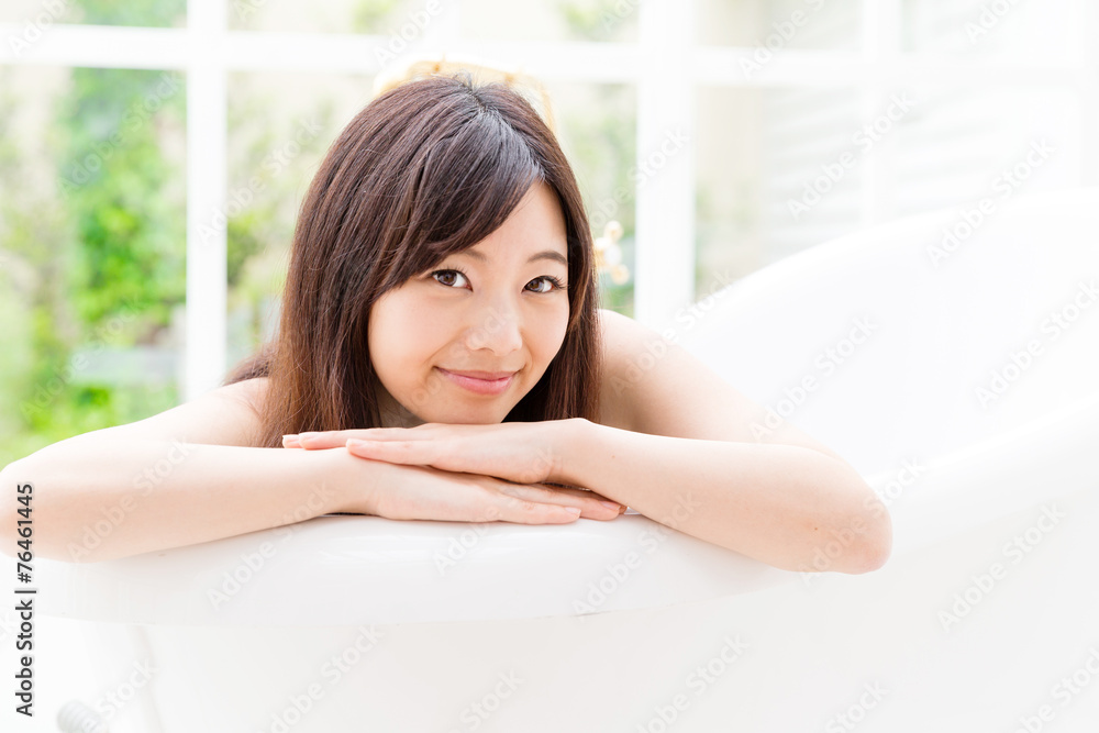 young asian woman relaxing in the bathtub