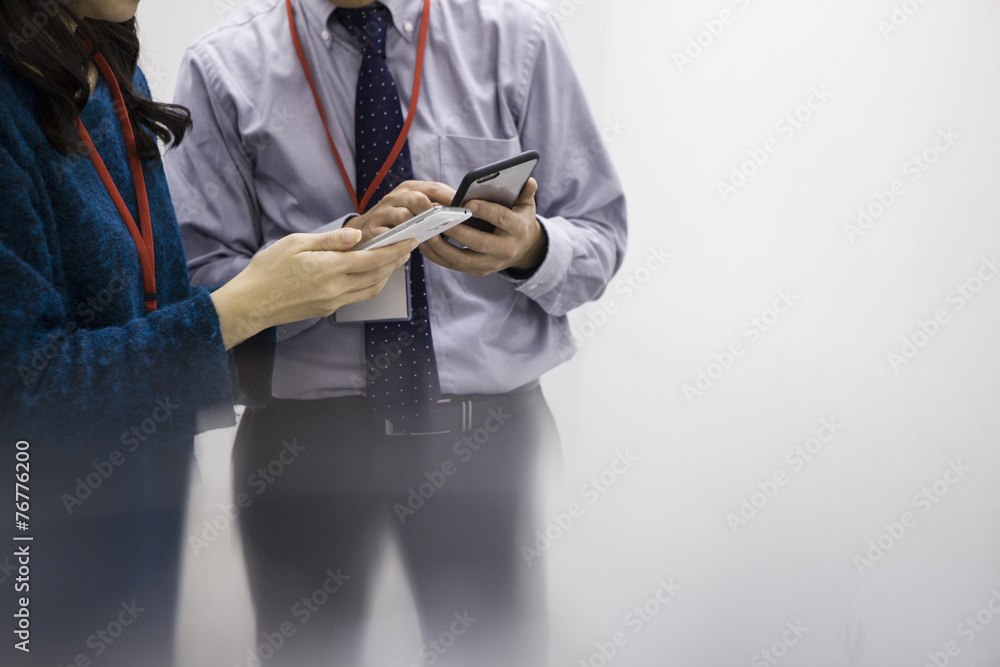 Two people that stand talking with a mobile phone