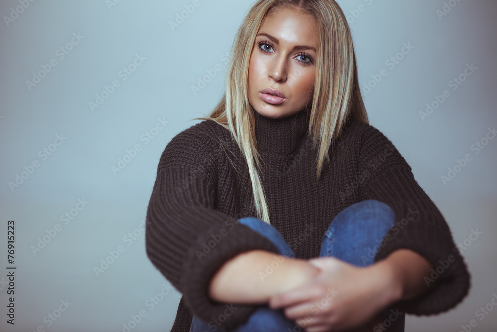 Pretty young woman sitting on floor