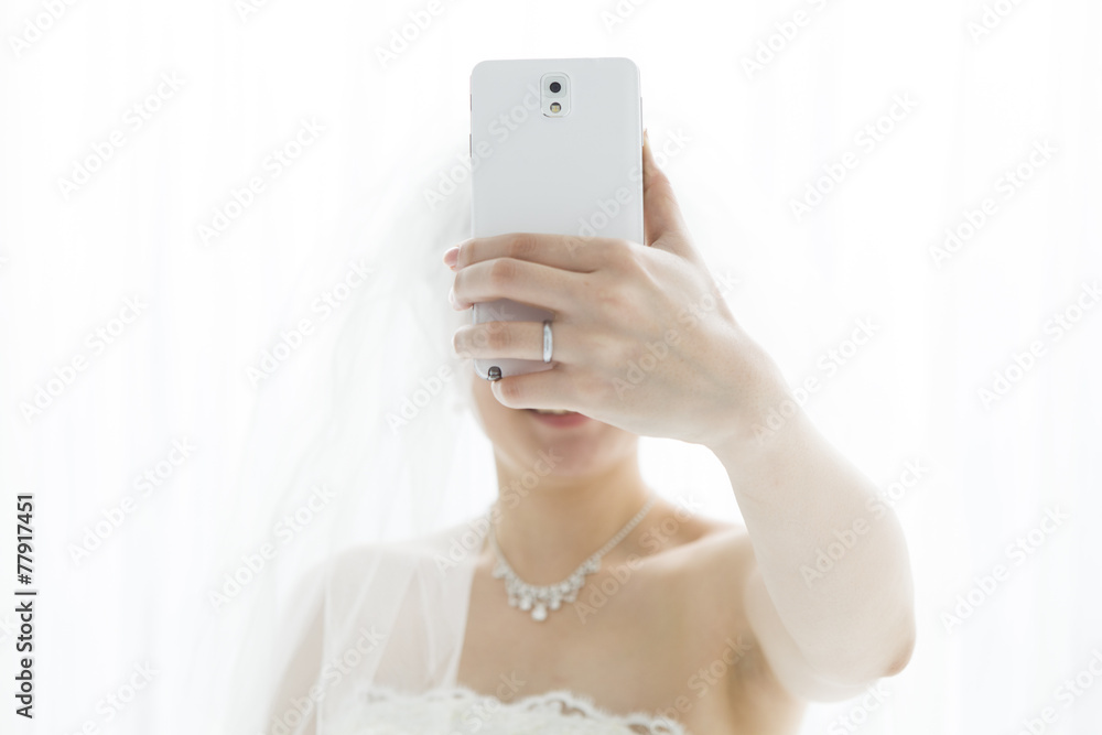 The bride, shooting themselves in the mobile phone