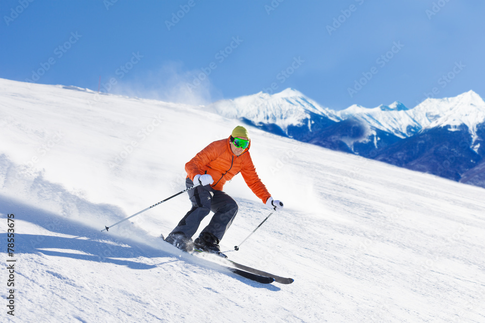 戴着滑雪面罩的年轻人在滑雪时快速滑行