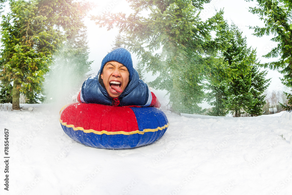 疯狂男孩在冬季冷杉林的雪管上