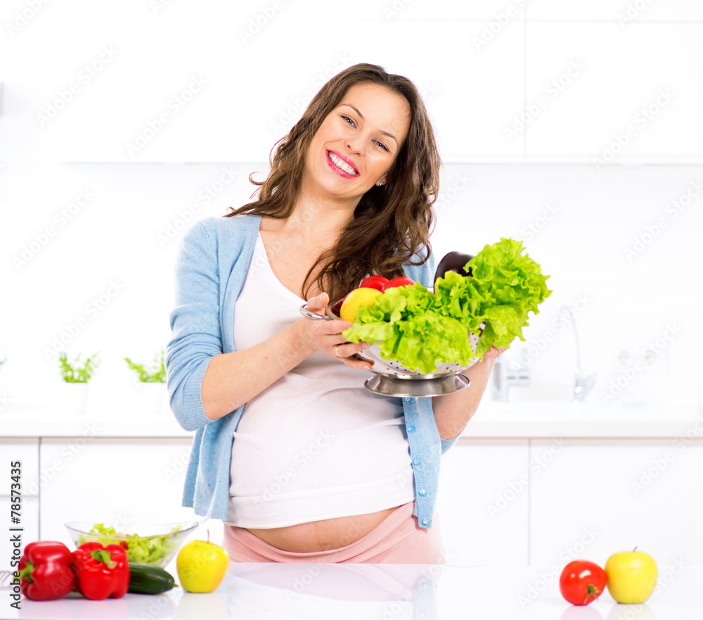 怀孕的年轻妇女烹饪蔬菜。健康食品