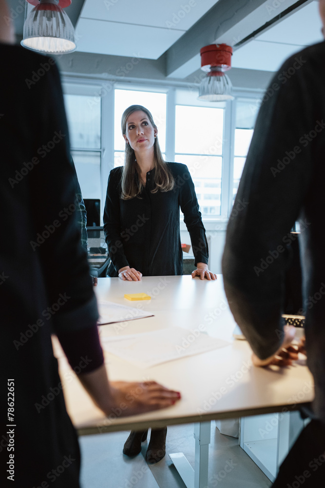 年轻女性高管与同事围坐在一张桌子旁