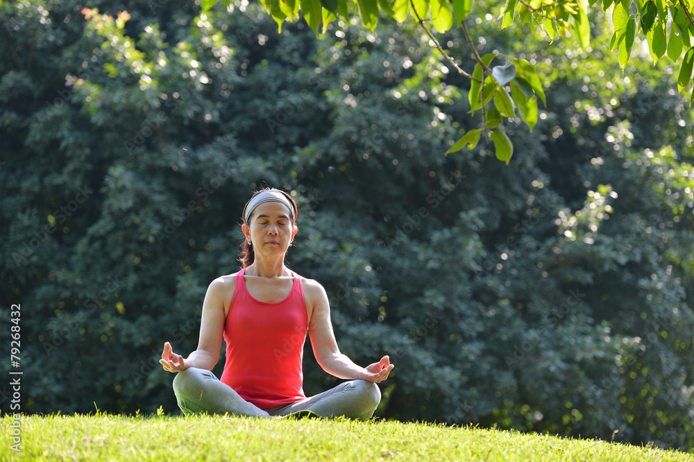 Middle aged woman doing yoga posture outdoor