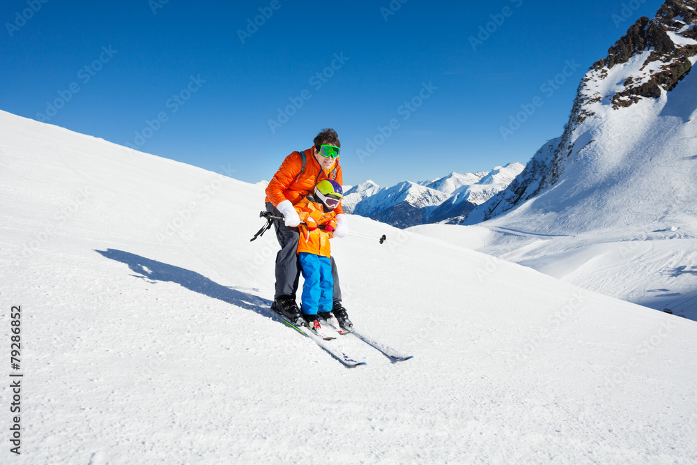 爸爸教小儿子在山上滑雪