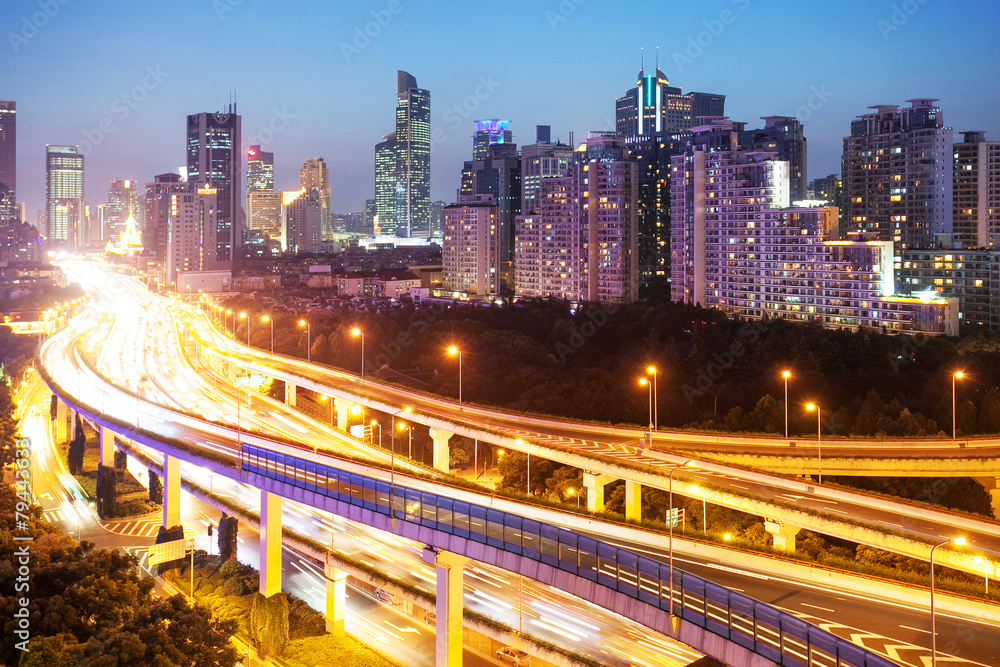 illuminated traffic on elevated expressway in modern city.