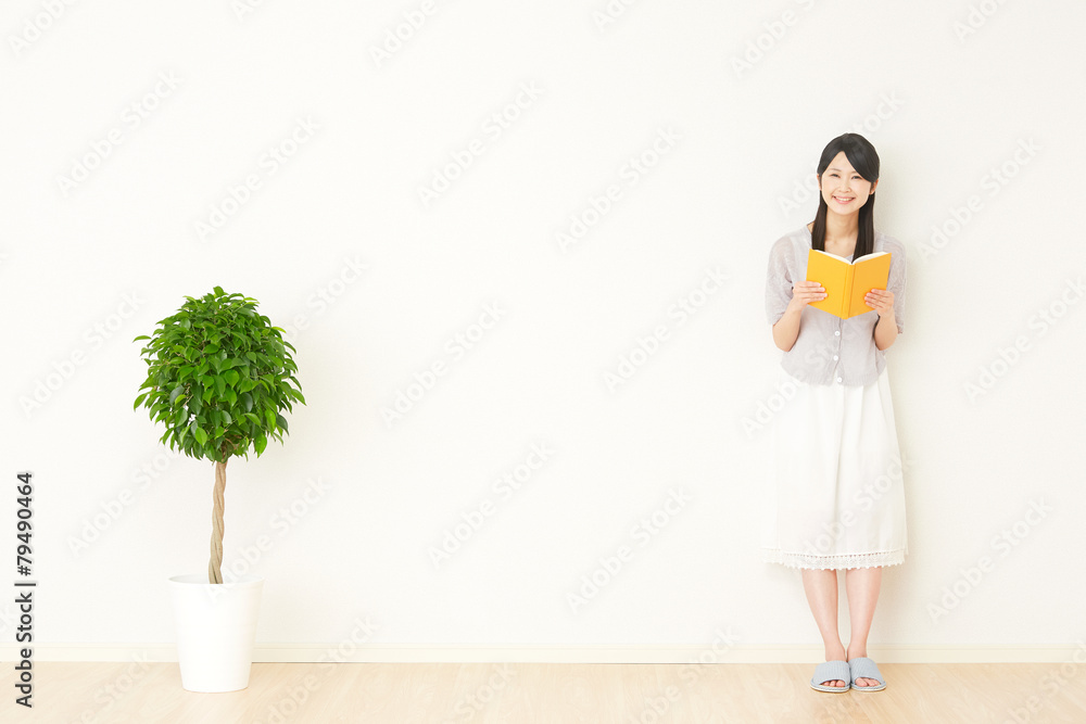 部屋で本を読む女性