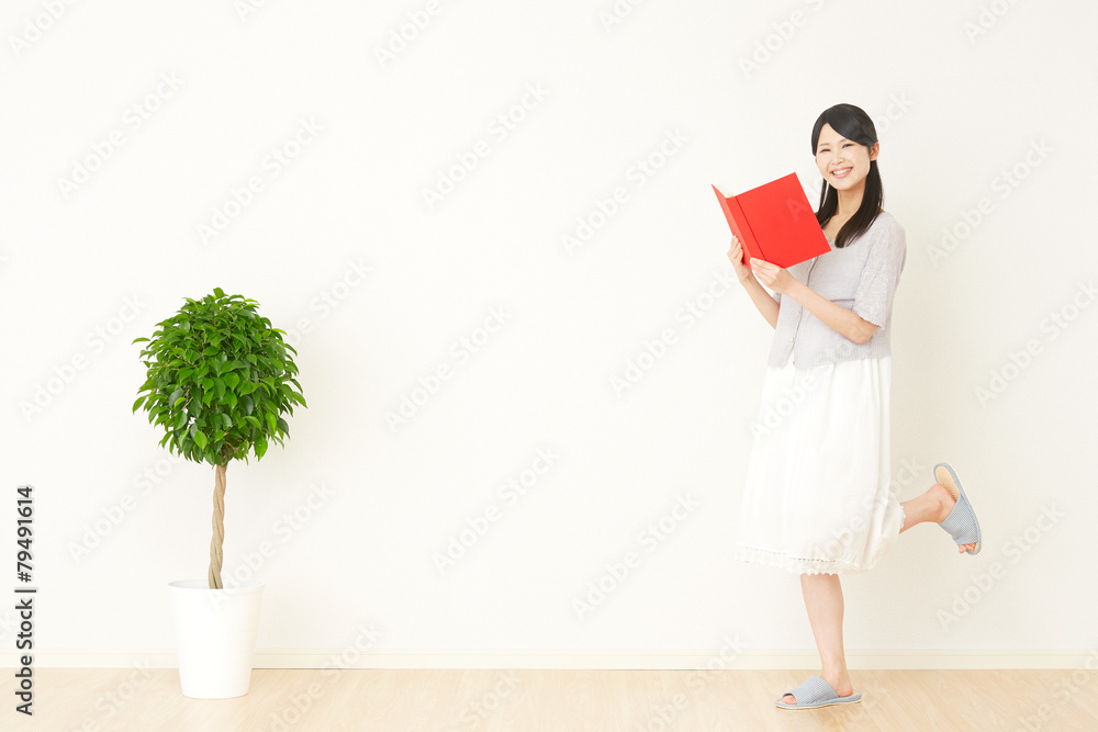 部屋で本を読む女性