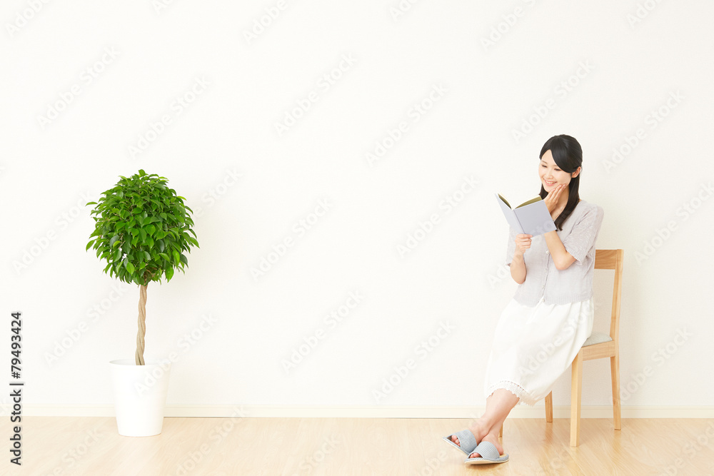 部屋で本を読む女性