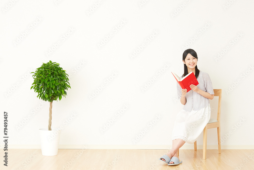 部屋で本を読む女性