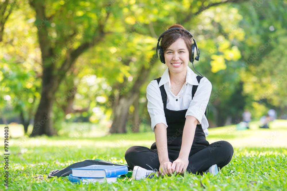 年轻漂亮的亚洲女人戴着耳机听音乐