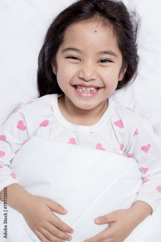 Lovely Asian child laying down on the bed