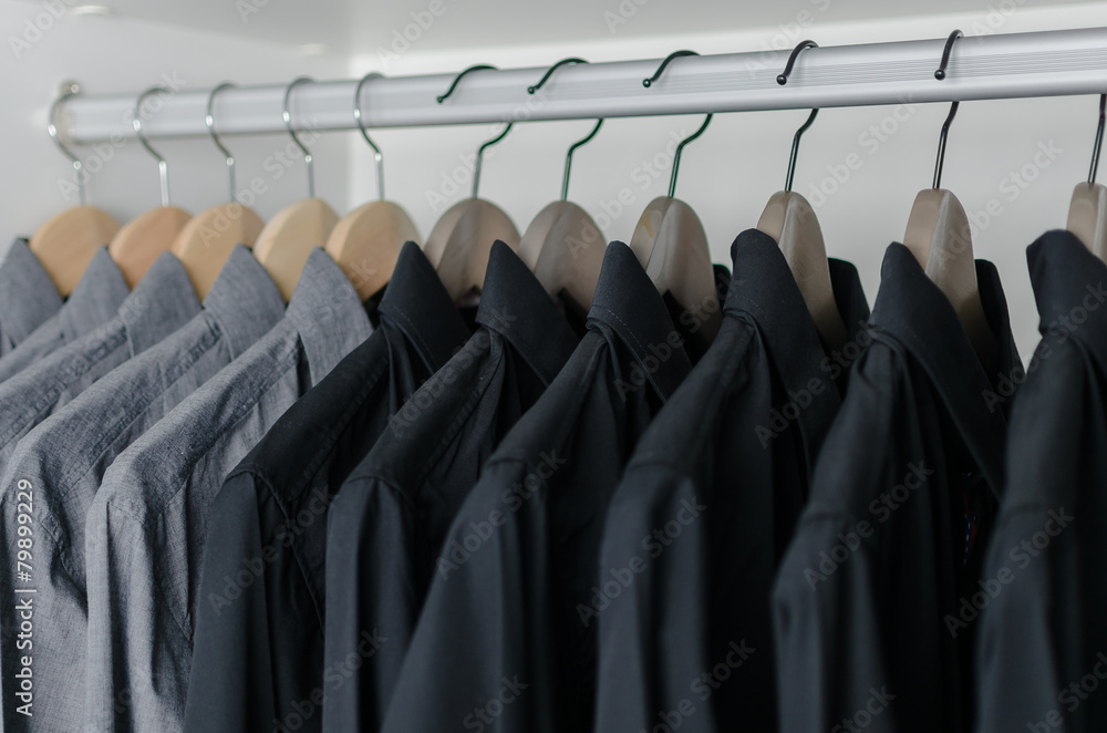 row of black shirts hanging on coat hanger