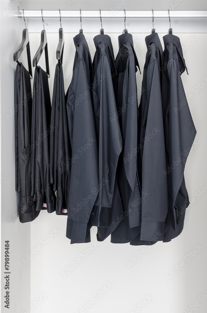 row of black shirts and pants hanging on coat hanger