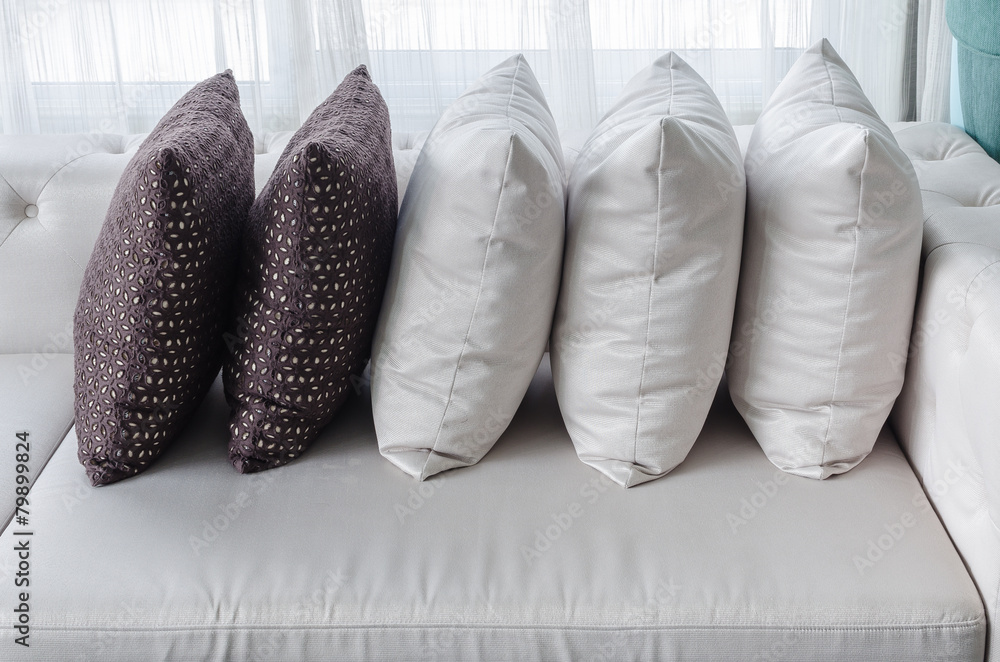 row of pillows on white modern sofa in living room